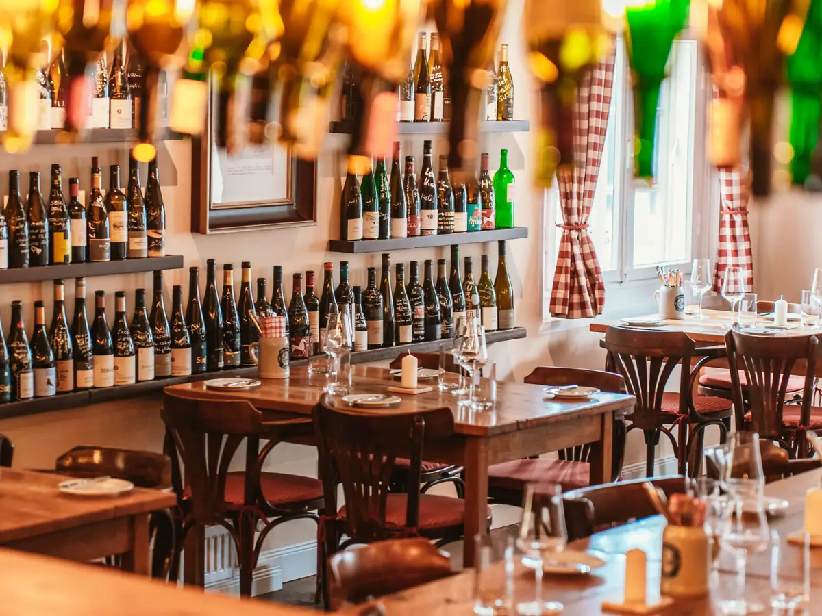 Innenraum der Weinwirtschaft "Kleines Jacob" mit hölzernen Stühlen und Tischen.