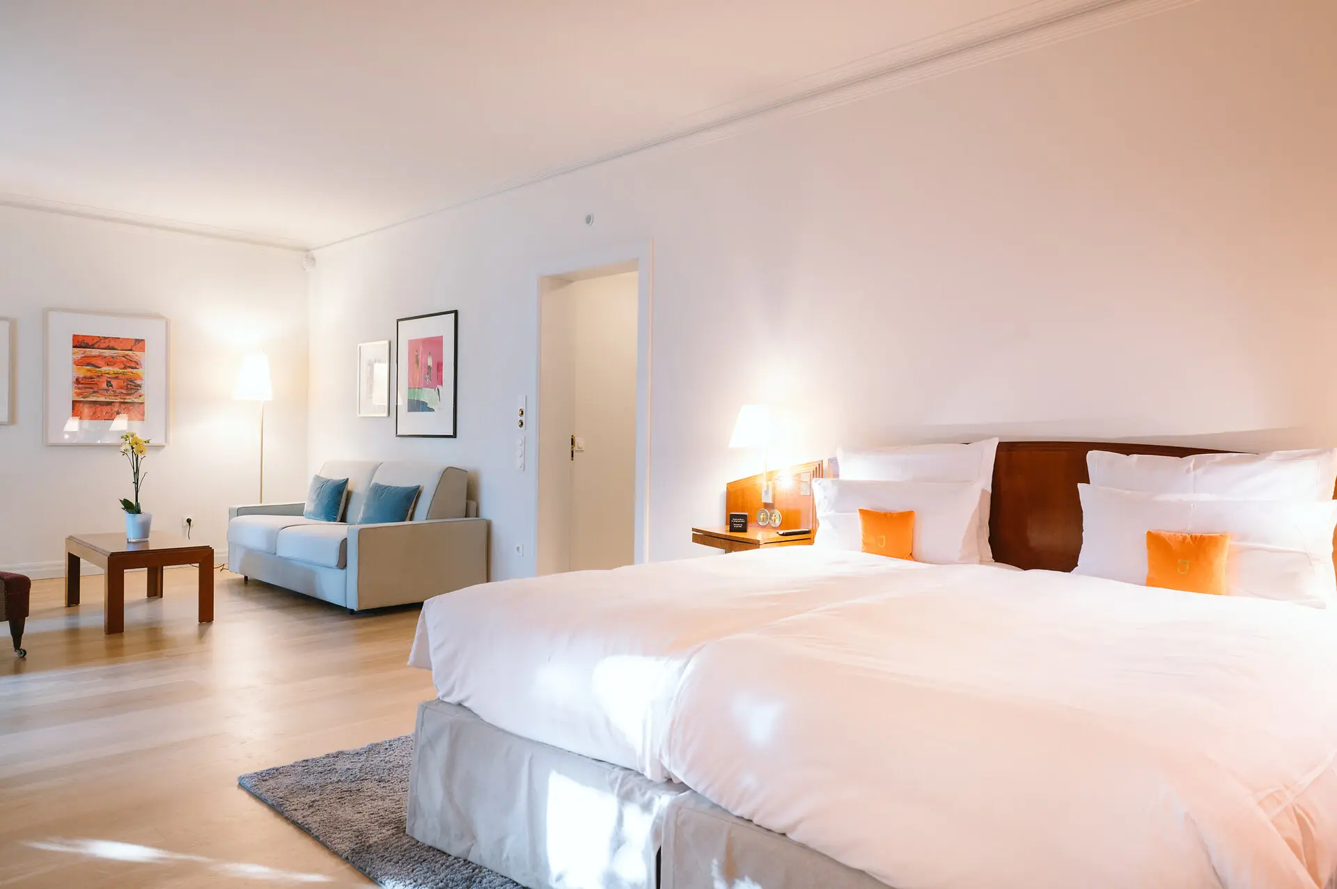 Studio Louis C. Jacob Hotel Hamburg A bedroom with a neatly made bed, couches, and elegant interior design.