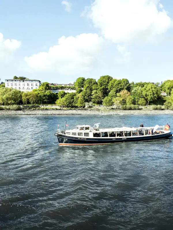 Die Barkasse MS Jacob auf der Elbe auf Höhe des Hotels Louis C. Jacob.