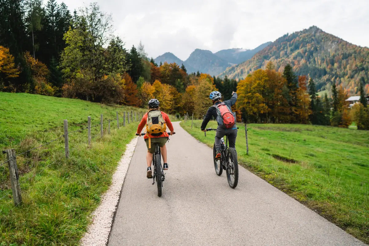Two people are cycling along a road.
