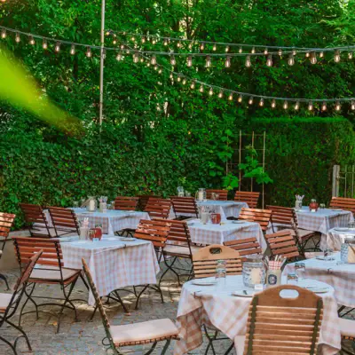 Tables and chairs outside with a string of lights.
