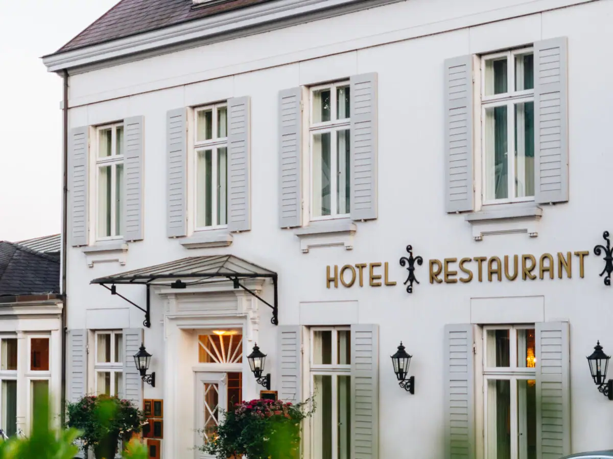 White building with a sign with the hotel name on it