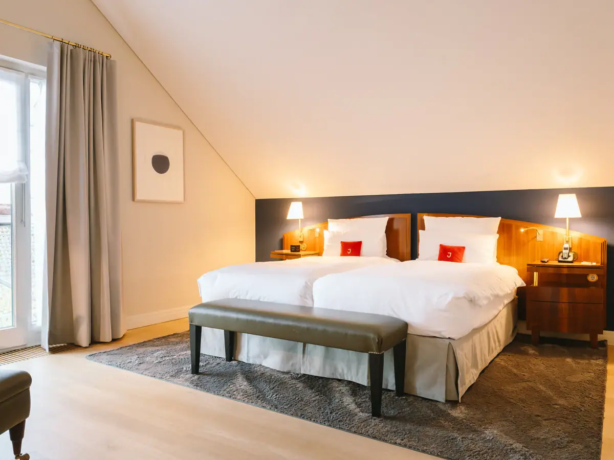 Hotelzimmer mit einem Bett und einer Bank.