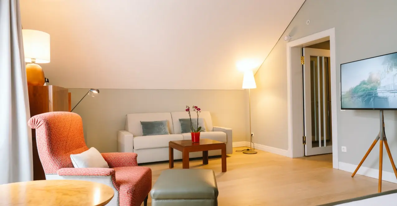 Interior view of a hotel room with a bed and a couch.