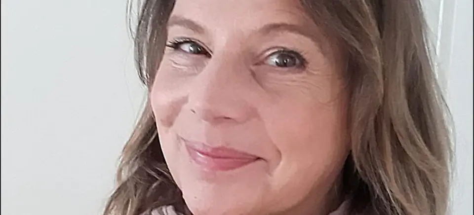 A woman smiling for a selfie, wearing a shawl.