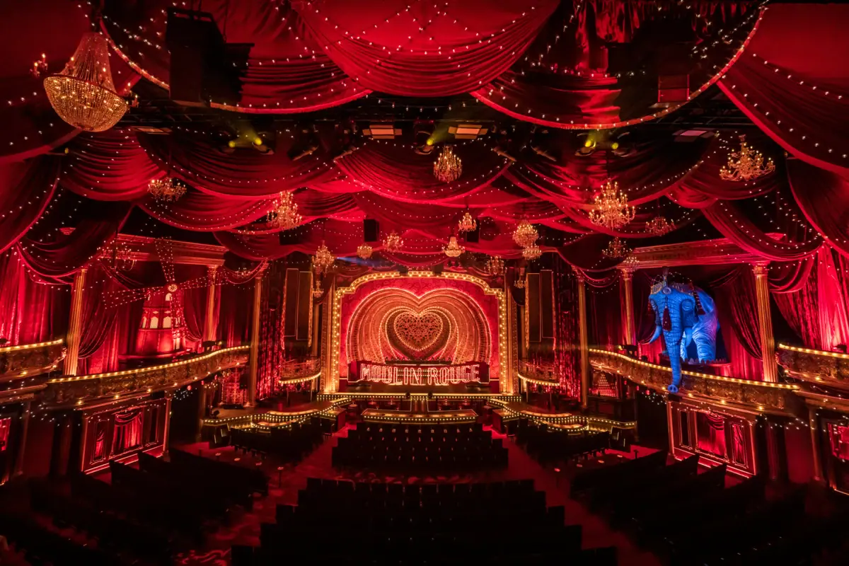 Moulin Rouge! The Musical at the Theater am Großmarkt A stage with red curtains and lighting in the theatre.