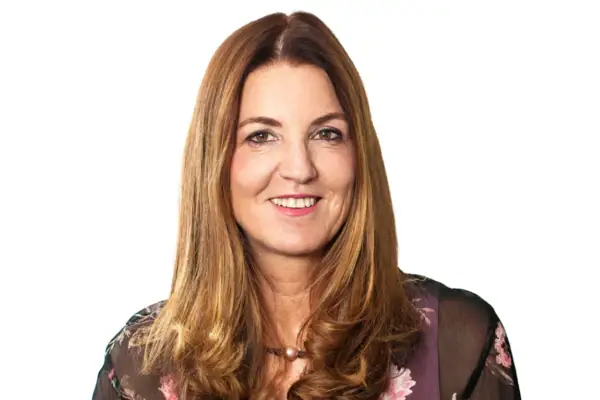 Susan Sieg Eine Frau mit langen, hellbraunen Haaren lächelt.