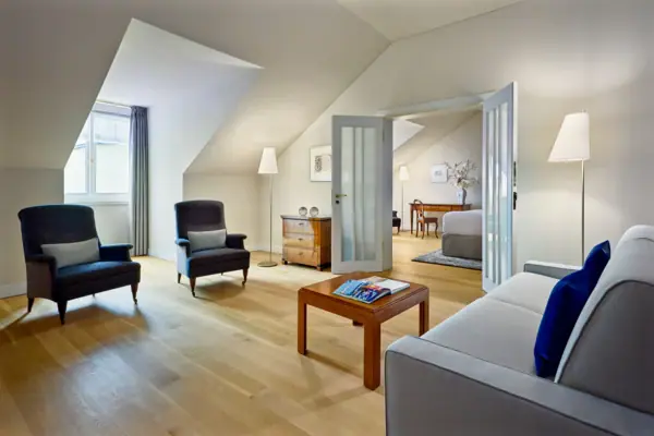 Suite city view Louis C. Jacob Hotel A room with a couch and a table, featuring indoor furniture and interior design elements.