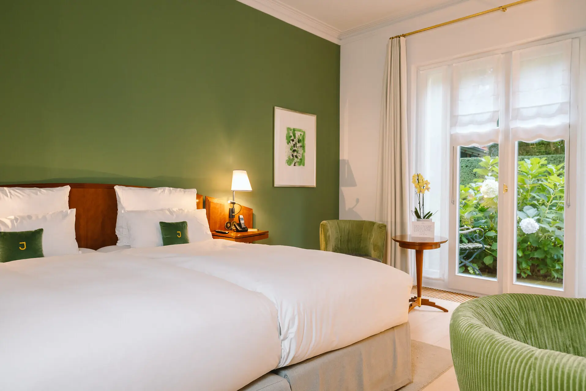 Deluxe double room Louis C. Jacob Hamburg A bedroom with green walls and a neatly made bed.