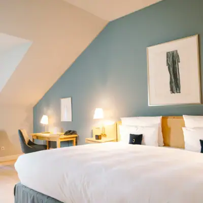 Zimmer Louis C. Jacob Ein Hotelzimmer mit einem Bett und Schreibtisch mit einem Stuhl davor.
