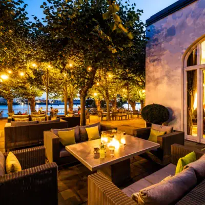 A patio with a table, chairs, and trees.