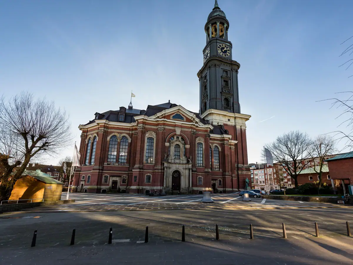 A large brick building with a prominent clock tower against a clear sky.