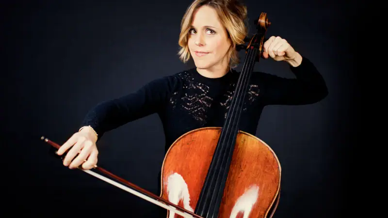 sol_gabetta_c_julia_wesely__4.jpg Sol Gabetta sitzt vor einem dunklen Hintergrund und spielt Cello.