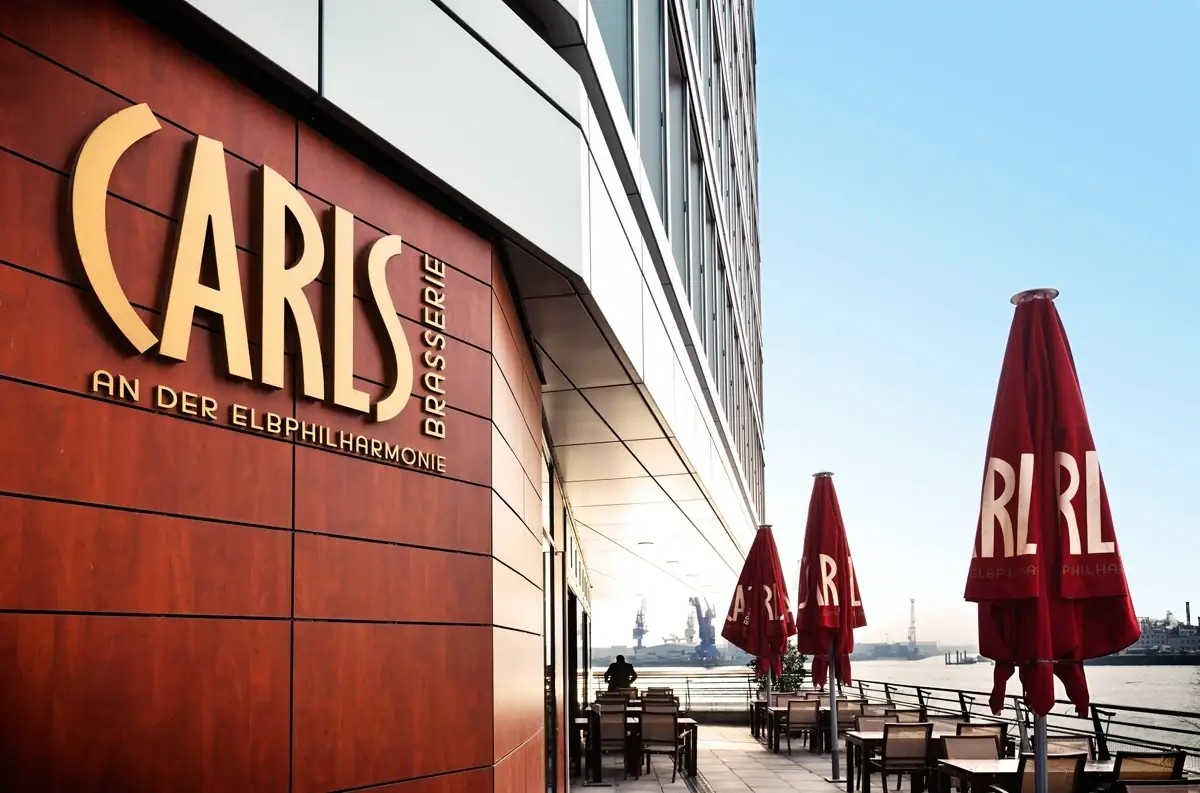 CARLS Restaurant Hamburg CARLS Restaurant an der Elbphilharmonie mit Tischen und Stühlen im Freien.
