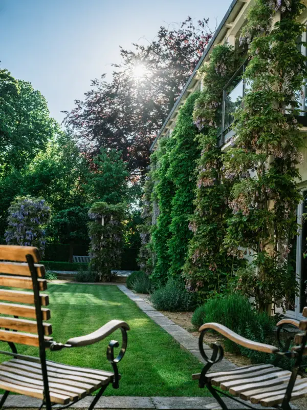 Zwei Gartenstühle im grünen Innenhof des Hotels Louis C. Jacob.