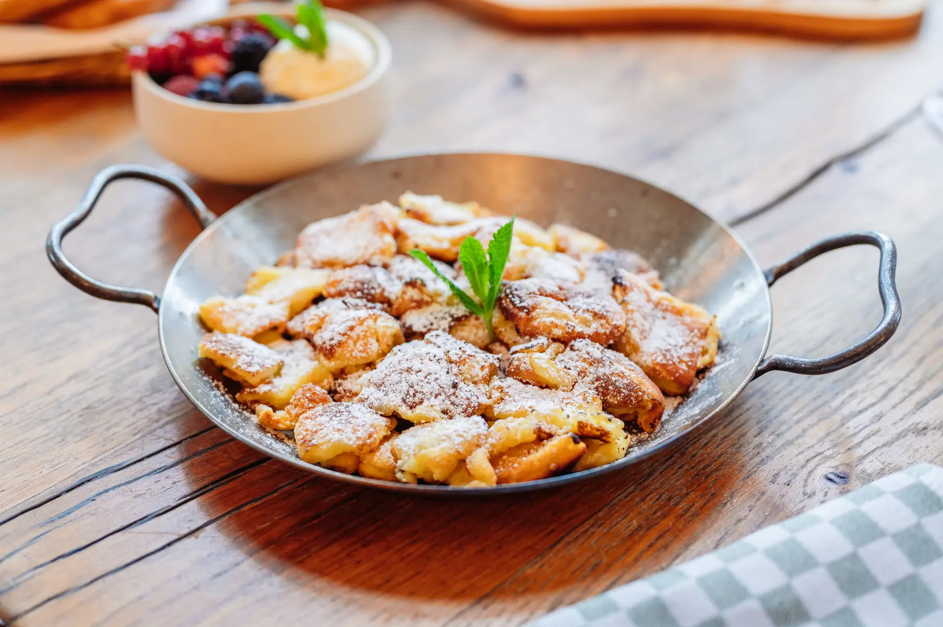 Caramelized Kaiserschmarrn A pan of food dusted with powdered sugar.