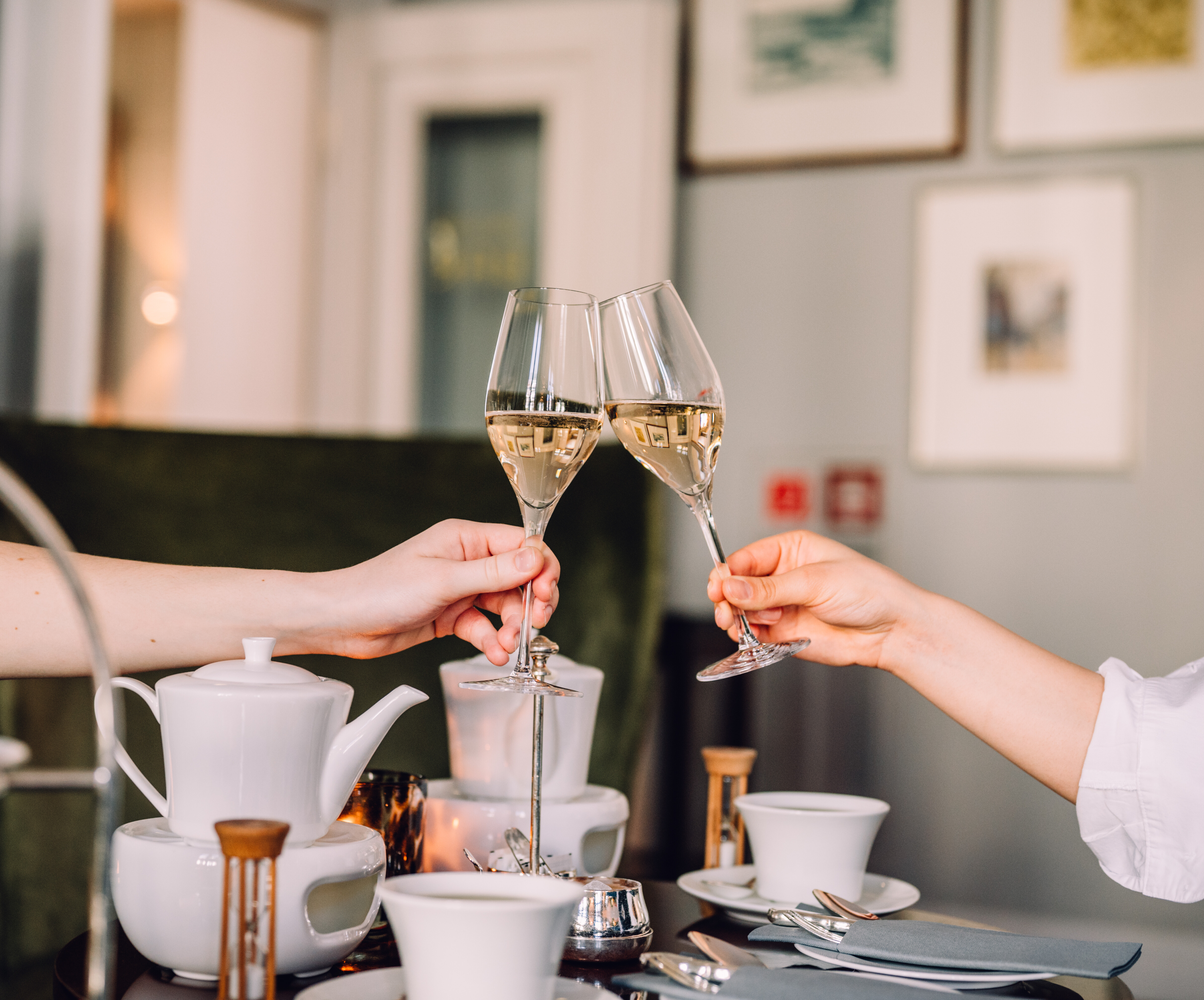 A pair of hands holds wine glasses.
