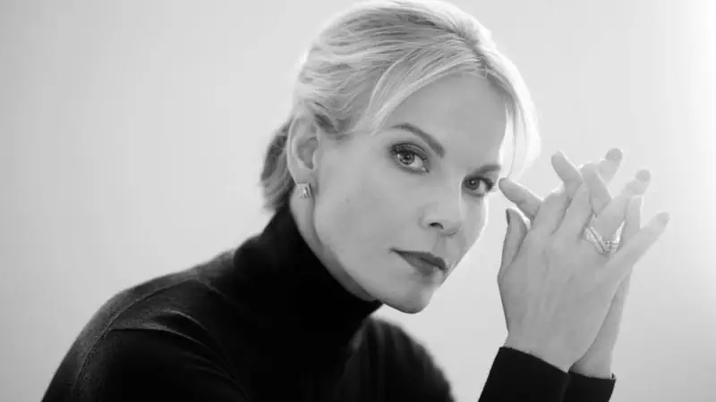 Elīna Garanča A woman touches her eye in a black and white portrait.