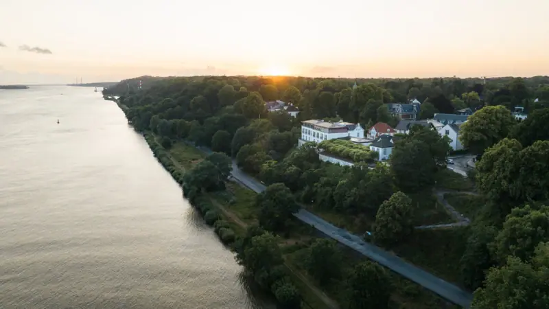 A body of water with buildings and trees in the background