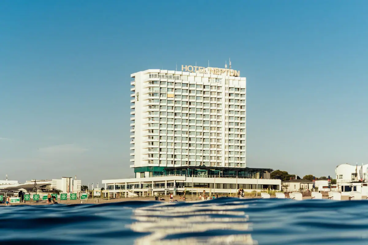 A building in the background of a body of water, with a clear sky.