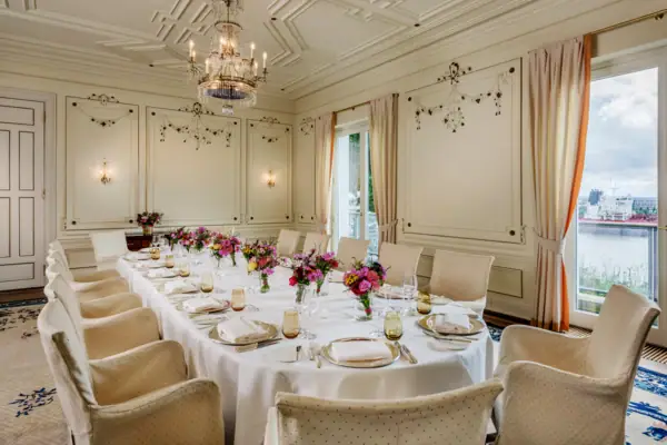 Veranstaltungsraum im Louis C. Jacob mit einer langen Tafel, die mit Blumen geschmückt ist.