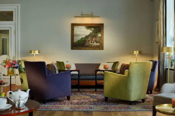 Wohnhalle im Hotel Louis C. Jacob mit Sofa, Sesseln und dem Gemälde der Lindenterrasse an der Wand.