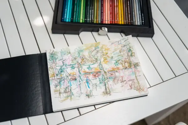 Skizzenbuch mit Buntstiften auf einem Tisch