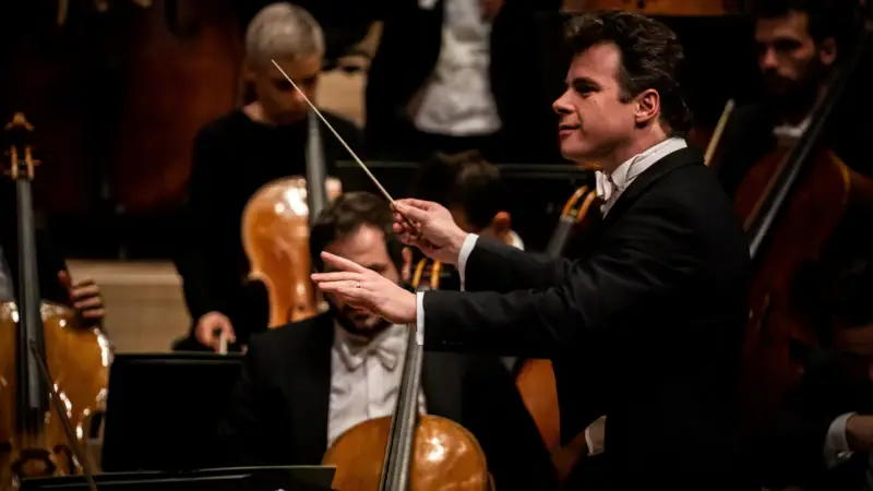 Jakub Hrůša dirigiert eine Gruppe von Musikern.