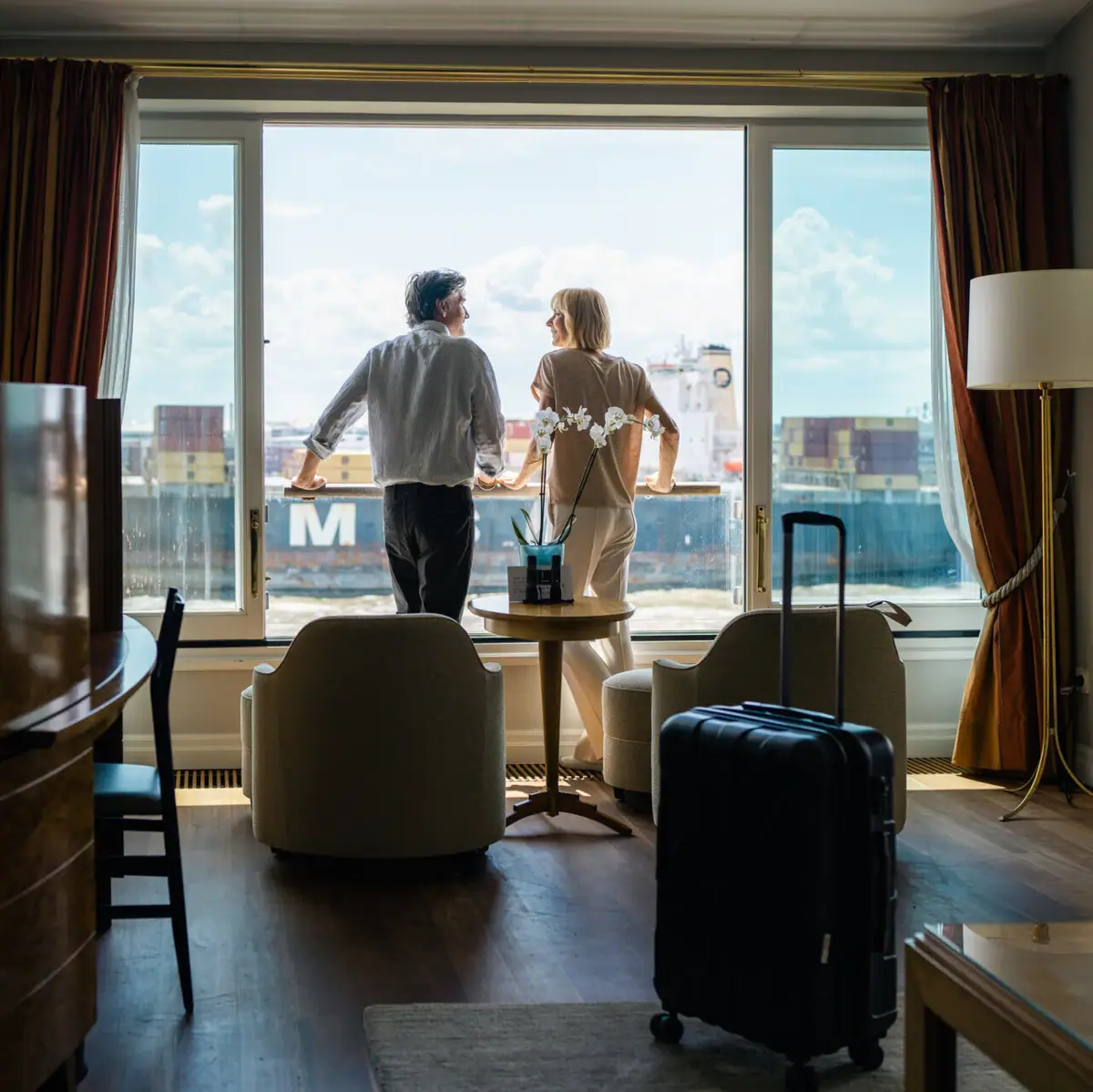 A man and woman standing in a room with a window.