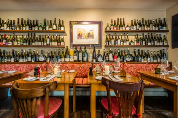 Table with wine bottles displayed on the wall.