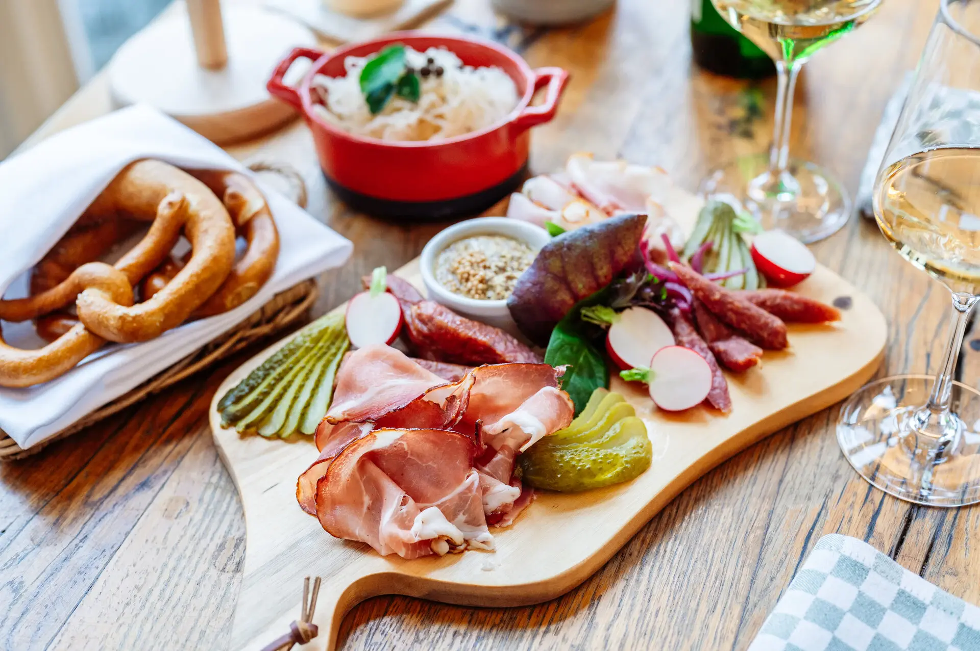 Schmankerl Board A wooden board with assorted meats and vegetables arranged artfully.