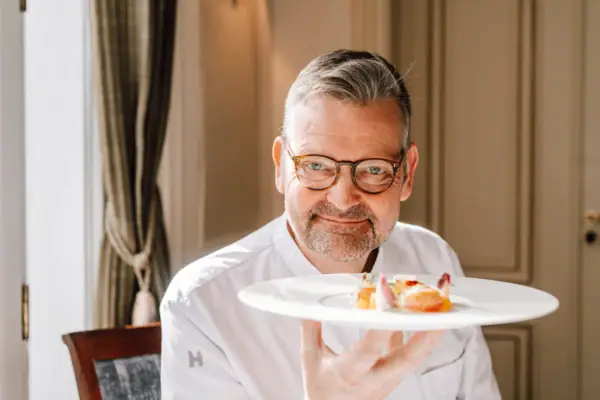 A man holding a plate of food indoors.