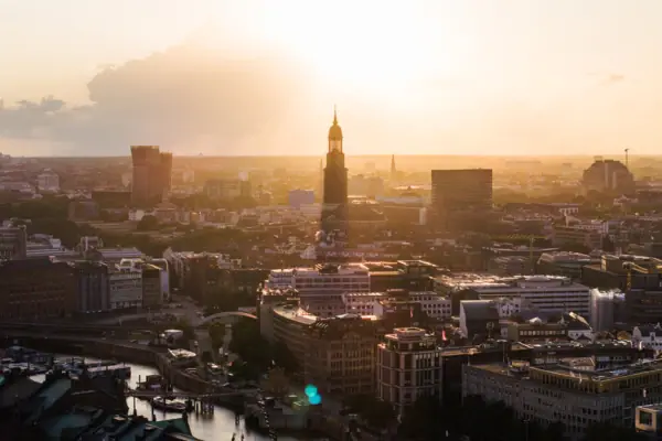 A town with a tall tower at sunset.