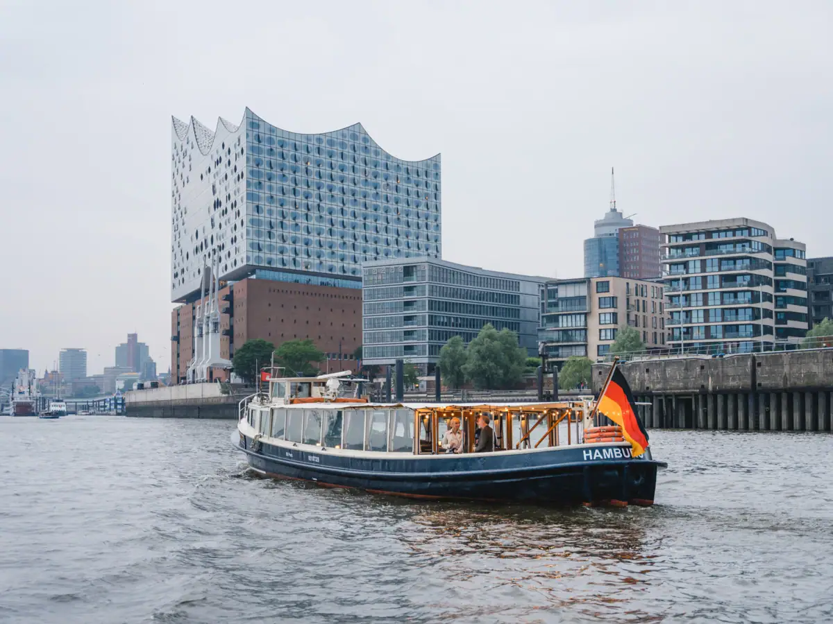 Die Barkasse MS Jacob auf der Elbe mit dem Gebäude der Elbphilharmonie Hamburg im Hintergrund.