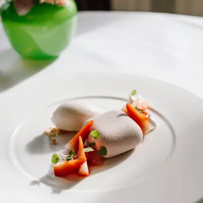 A plate of artfully presented food with garnish on a table.