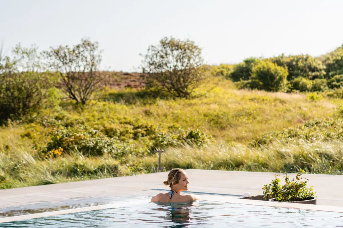 A woman in an outdoor swimming pool.