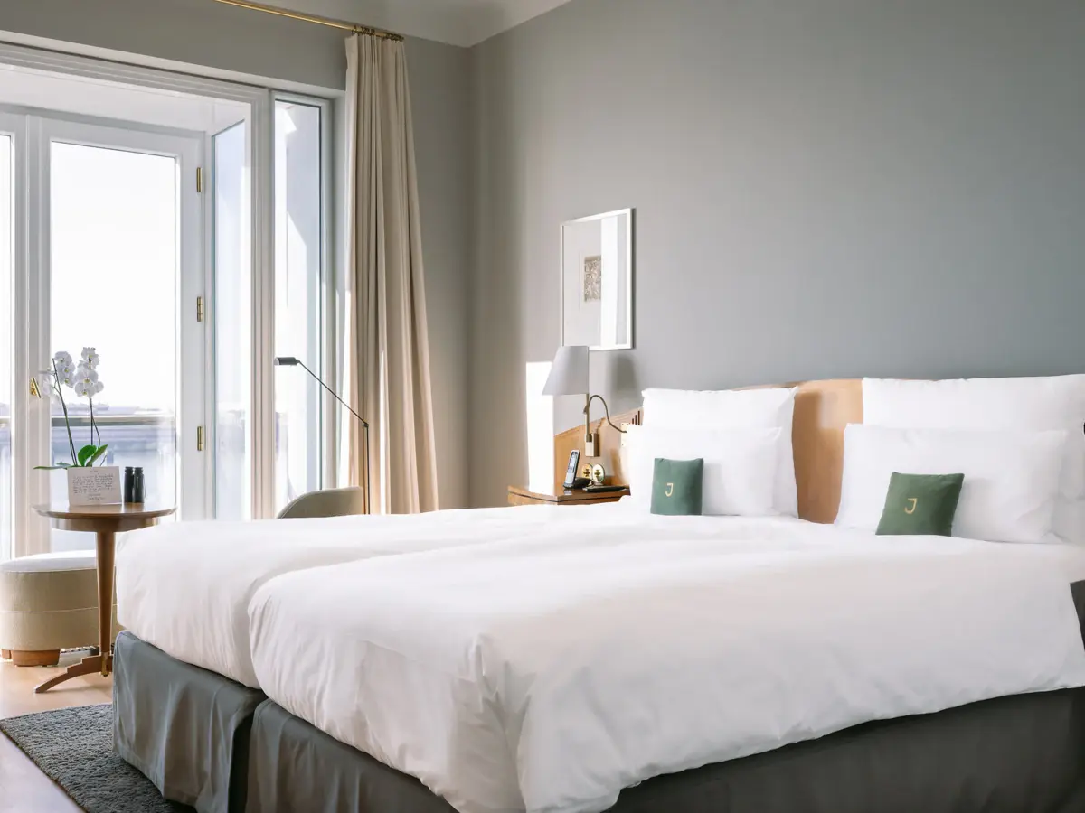 Zimmer Louis C. Jacob Ein Hotelzimmer mit einem Bett mit weißen Bettlaken und einem großen Fenster mit Blick auf die Elbe.