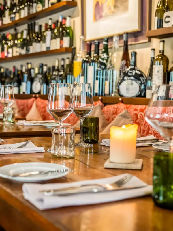 A table set with wine glasses and lit candles.