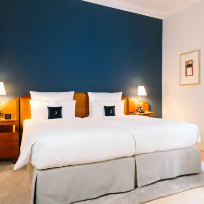 Zimmer Louis C. Jacob Bett in einem Zimmer mit dunkelblauer Wand im Hotel Louis C. Jacob.