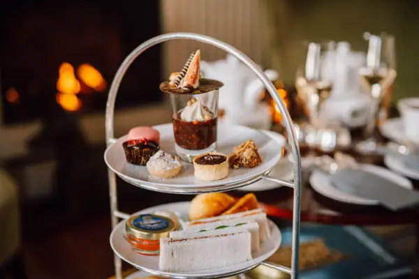 Etagere gefüllt mit herzhaften und süßen Köstlichkeiten vor dem Kamin in der Wohnhalle des Hotels Louis C. Jacob.