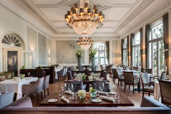 Jacobs Restaurant - A room with tables, chairs and chandeliers.