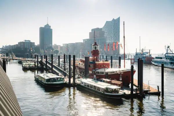 Blick von der Elbpromenade aus auf den Hafen Hamburg, das Feuerschiff und im Hintergrund die Elbphilharmonie.