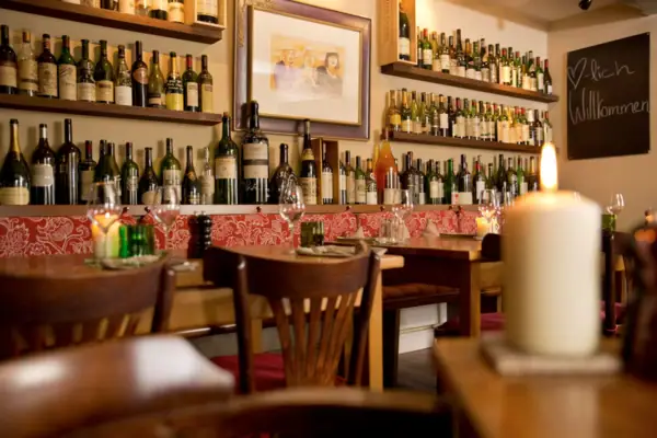 A room featuring wine bottles and candles on a table.