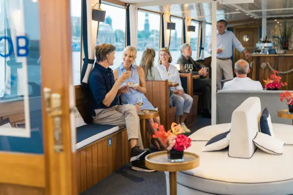 Several people sit on board the barge MS Jacob.