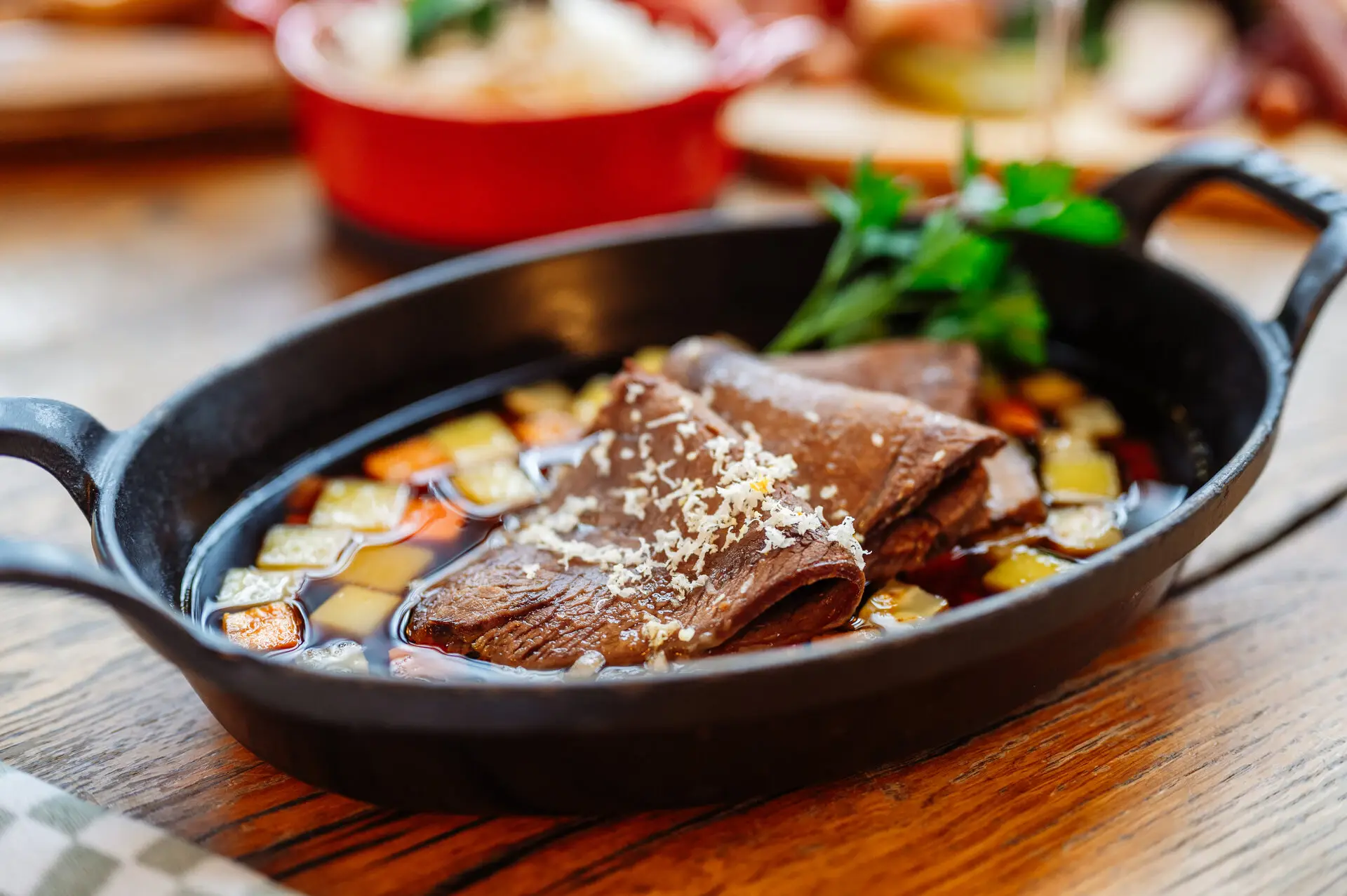 Boiled Beef (Tafelspitz) A bowl of soup with meat and vegetables.